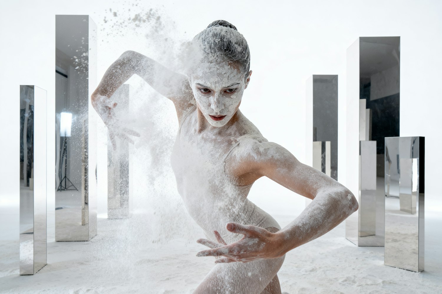 Dancer in motion surrounded by clouds of white powder